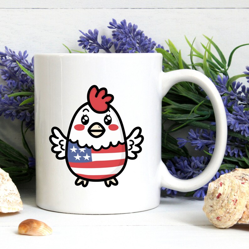May include: White ceramic mug with a cartoon chicken wearing an American flag design. The chicken has red comb and wattle, black eyes, and a yellow beak.