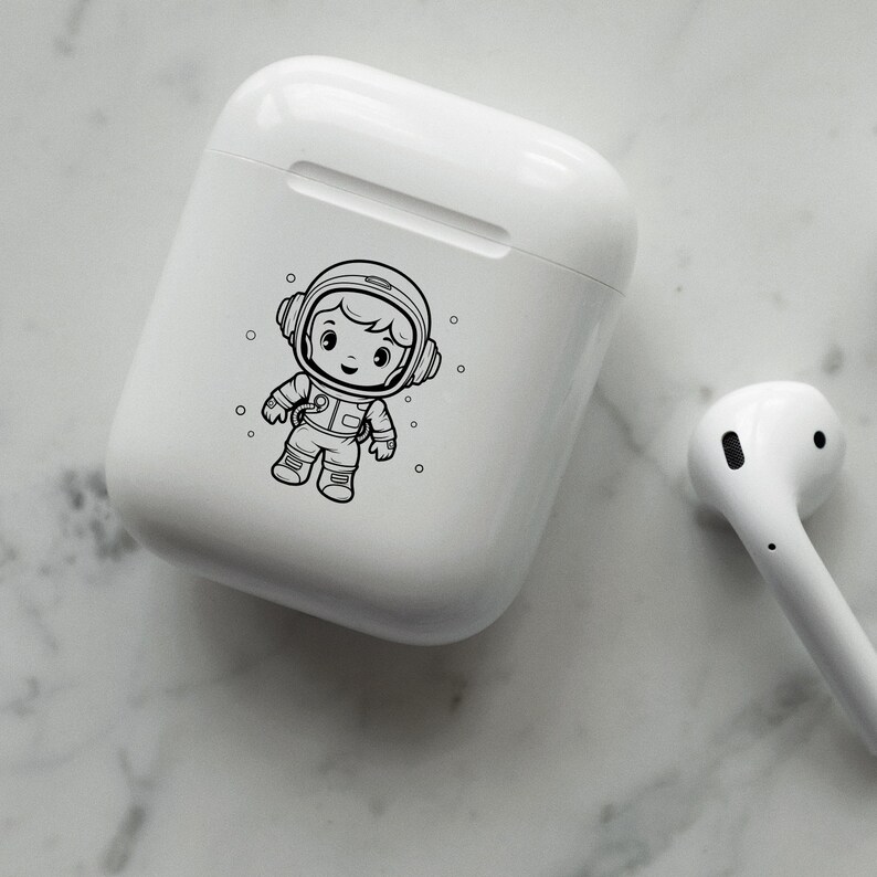 May include: White wireless charging case with a black and white illustration of an astronaut. The astronaut is wearing a helmet and a spacesuit.