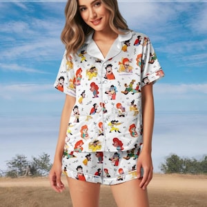 May include: A white ceramic mug with a black handle and the text "But First, Coffee" in a black, handwritten-style font. The mug is on a white surface.