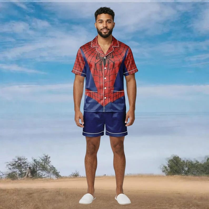 May include: A Spider-Man themed pajama set. The short-sleeved top is red and blue with white trim, resembling the superhero's costume. The matching shorts are navy blue with white trim. The set is made of a shiny, silky material. The pajamas are designed for comfort.