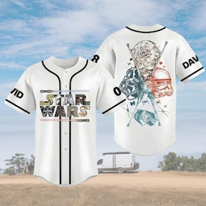 May include: White baseball jersey with black trim and the text "STAR WARS" on the front. The jersey features Star Wars character graphics on the back and sleeves. The name "DAVID" is on the right sleeve.