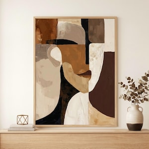 Könnte beinhalten: Abstrakter Kunstdruck mit einem Gesicht, das aus geometrischen Formen in Braun-, Beige-, Schwarz- und Weißtönen besteht. Das Kunstwerk ist in einem hellen Holzrahmen gerahmt und hängt über einem Holzschrank.