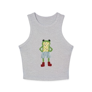 May include: A gray tank top featuring a whimsical frog design. The frog has a floral pattern body, striped shorts, and red boots. The frog's eyes are black, and it has a green head.