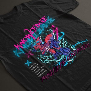 May include: A black t-shirt with a pink and blue graphic of a monster with the text "Knowledge is Power" and "MegaKabuterimon" in a stylized font. The text "Curiosity sparks the flame of wisdom, seek knowledge without end." is also included.
