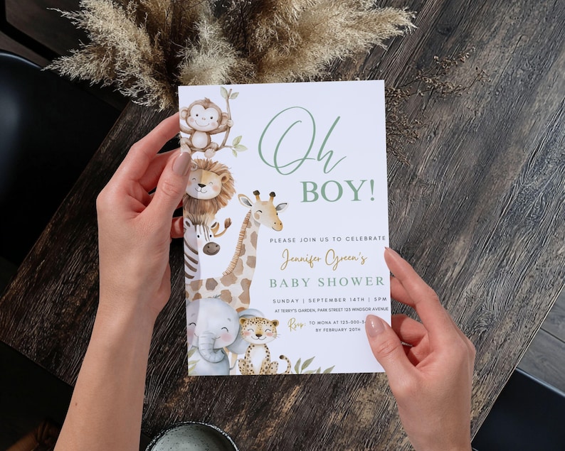 Puede incluir: Una invitaci&oacute;n a un baby shower con el texto "Oh Boy!" en verde. La invitaci&oacute;n presenta ilustraciones de animales de la jungla, incluyendo un mono, un le&oacute;n, una cebra, una jirafa, un elefante y un leopardo. La invitaci&oacute;n es sostenida por una persona.