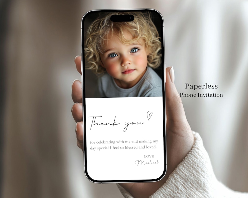 May include: A smartphone displays a digital invitation with a child's portrait. The text reads "Thank you" with a heart, followed by a message and "Love, Michael." The phone's screen also displays "Paperless Phone Invitation."