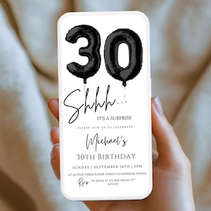 May include: A smartphone displays a birthday invitation. The invitation features black balloon-shaped numbers forming "30" and the text "Shhh... It's a Surprise." Below, it reads "Michael's 30th Birthday" with date, time, and location details.
