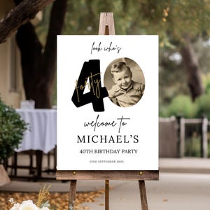 May include: Black and gold 40th birthday party welcome sign with a photo of a young boy. The sign says "Look who's forty" and "Welcome to Michael's 40th Birthday Party".