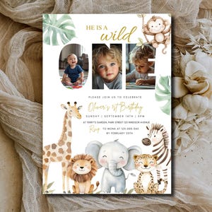 May include: A birthday invitation with a jungle theme. The invitation features a photo of a baby, the words "HE IS A WILD ONE", and illustrations of a giraffe, lion, elephant, cheetah, zebra, and monkey. The invitation includes the date, time, and location.