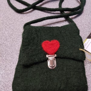 May include: A dark green felt bag with a red felt heart and a silver clasp. The bag has a long dark green felt strap.