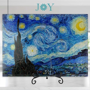 May include: A framed print of Vincent van Gogh's "Starry Night" painting. The painting features a swirling blue sky with bright stars and a yellow crescent moon. A dark cypress tree stands in the foreground, and a small village is visible in the distance.