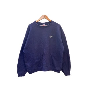 Op de afbeelding: Een marineblauw sweatshirt met een wit Nike-logo op de voorkant.