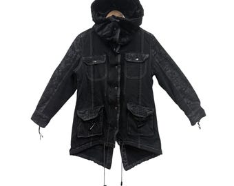 May include: Black hooded jacket with a faux fur-lined hood and four front pockets. The jacket features white stitching and textured panels on the sleeves. It has a drawstring at the bottom and on the hood.