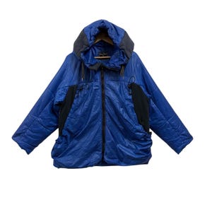 May include: A blue hooded jacket with a black zipper and black accents on the sides. The jacket has a quilted texture and a drawstring hood. The jacket is made of a shiny material.