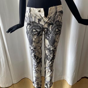 Peut inclure: Pantalon blanc court à imprimé serpent noir et blanc.