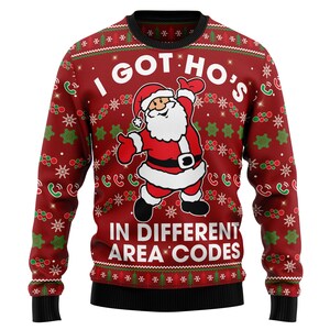 May include: Red Christmas sweater with a Santa Claus graphic and the text "I GOT HO'S IN DIFFERENT AREA CODES". The sweater has a black collar and cuffs, and a festive pattern of snowflakes and Christmas trees.
