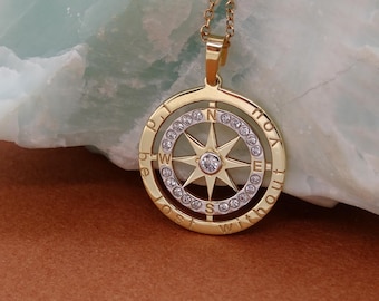 May include: Gold-toned compass pendant necklace. The pendant features a compass rose design with a central diamond and surrounding clear stones. The outer ring has the words "Lost Without You".