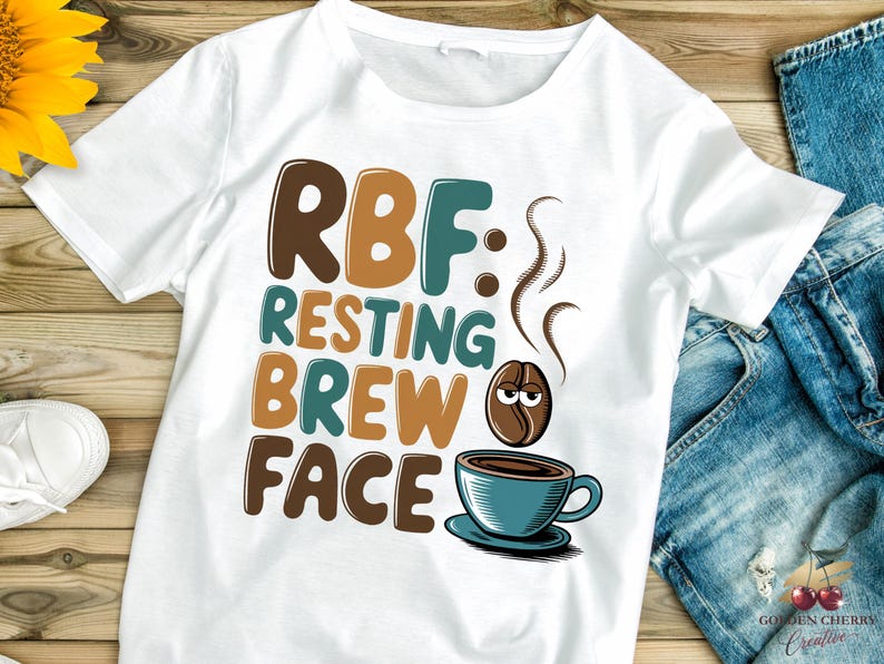 May include: White t-shirt with brown, teal, and orange text that reads "RBF: Resting Brew Face". A cartoon coffee bean with a face is above a teal coffee cup with brown coffee inside.