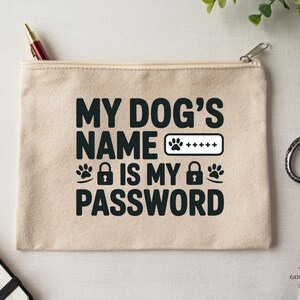 May include: A beige canvas zippered pouch with the text "MY DOG'S NAME IS MY PASSWORD" in black. The design includes paw prints, a lock icon, and a password field. A pen and scissors are visible.