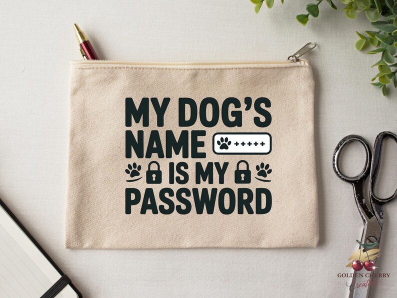 May include: A beige canvas zippered pouch with the text "MY DOG'S NAME IS MY PASSWORD" in black. The design includes paw prints, a lock icon, and a password field. A pen and scissors are visible.