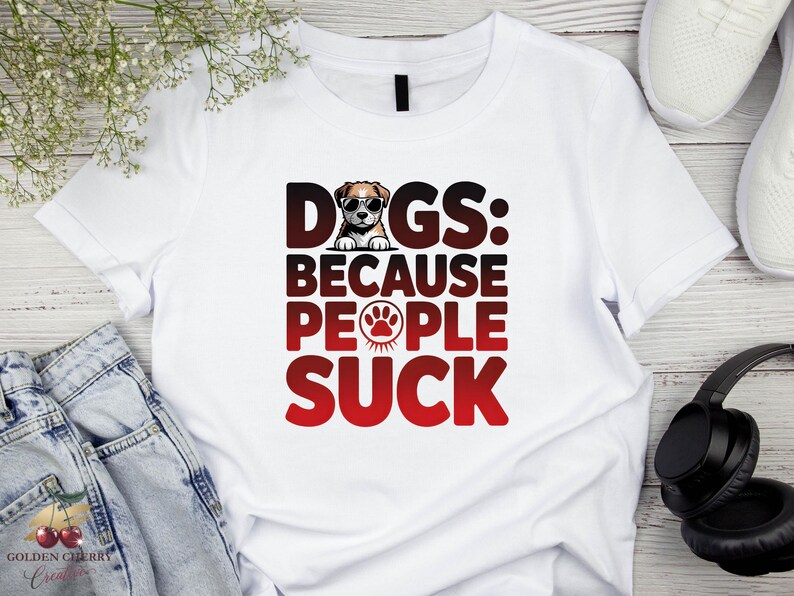 May include: White t-shirt with the text "DOGS: BECAUSE PEOPLE SUCK" in black and red. The word "DOGS" has a dog wearing sunglasses as the letter "O". A paw print is in the word "PEOPLE".