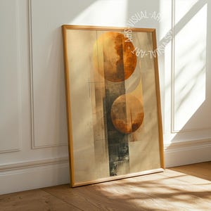 Könnte beinhalten: Ein gerahmter abstrakter Kunstdruck mit zwei großen orangefarbenen Kreisen und vertikalen rechteckigen Formen in Beige, Braun und Schwarz. Das Kunstwerk lehnt an einer weißen Wand, mit Sonnenlicht, das Schatten wirft.