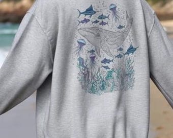 May include: A pale grey hoodie with a marine-themed design on the back. The illustration features a whale, fish, and jellyfish in blue and purple hues. The hoodie has a relaxed fit and a high neckline, suitable for casual wear.