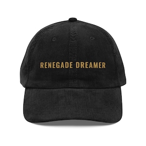May include: Black corduroy baseball cap with gold embroidery that reads "RENEGADE DREAMER".