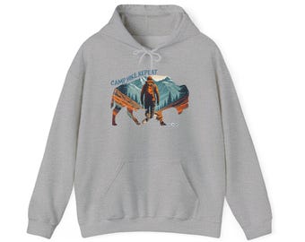 May include: A gray hooded sweatshirt with a graphic print of a hiker walking through a mountain landscape with the text "Camp Hike Repeat" above the image.