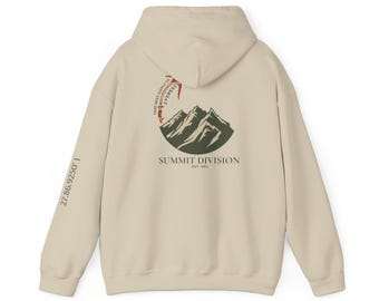 May include: A beige hoodie with a graphic of a mountain range inside a circle. The text "SUMMIT DIVISION EST. 1993" is below the graphic. The text "27.86.9250.1" is on the left sleeve.