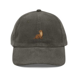 May include: A dark green corduroy baseball cap with an embroidered brown otter on the front.