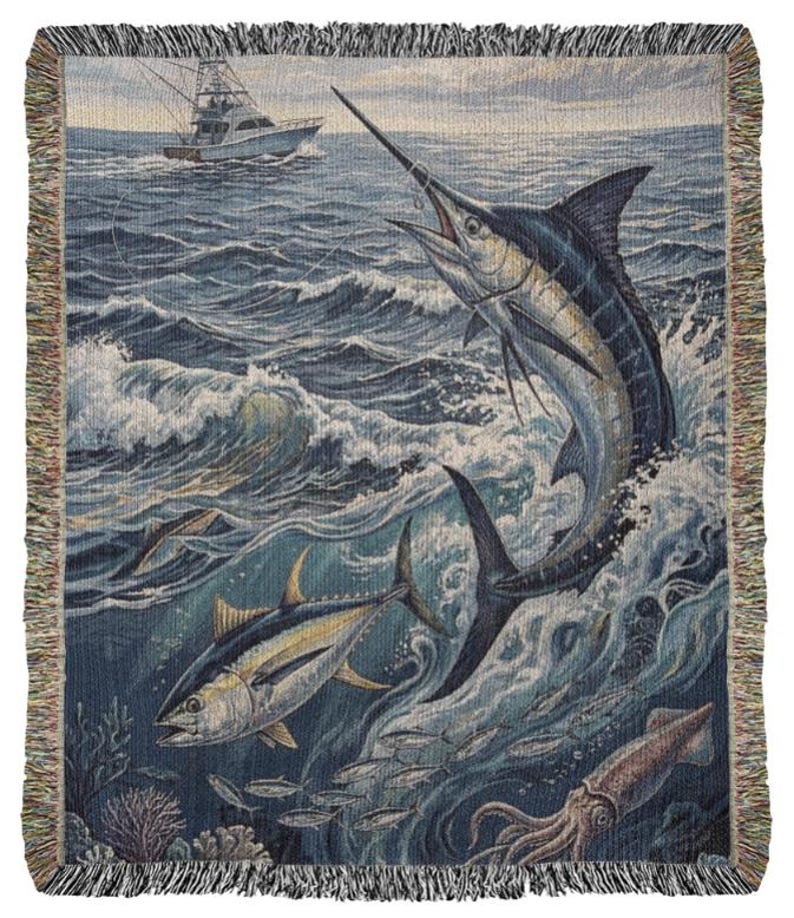 May include: Woven throw blanket featuring a marine scene with a marlin leaping from the ocean, a tuna, and a fishing boat. The blanket has a fringed edge and depicts a vibrant underwater world with shades of blue, green, and white.