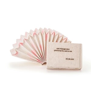 Puede incluir: Un abanico de papel blanco con detalles rosas, doblado en forma de libro. La portada del libro tiene un mensaje que dice "Gift Message Here Something you want to say XX.XX.20XX".