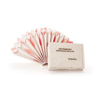 May include: A white paper fan with pink and red floral designs, folded into a book shape. The book has a blank white cover with the text "Gift Message Here Something you want to say XX.XX.20XX".