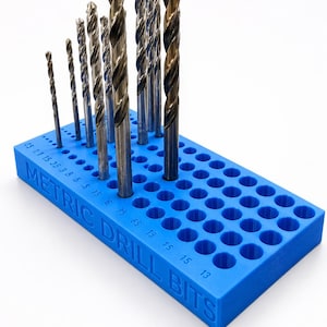 May include: A blue plastic drill bit organizer with multiple drill bits of varying sizes. The organizer has holes labeled with metric measurements. The text "METRIC DRILL BITS" is visible on the side.
