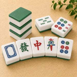 May include: A set of rectangular Mahjong tiles with white faces and green backs. The tiles feature various engraved symbols, including Chinese characters, circular patterns, and geometric shapes in red, green, and blue ink on the white surfaces.
