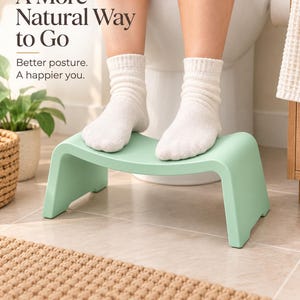 May include: A light green plastic toilet stool with a curved top surface. The text on the image reads: A More Natural Way to Go. Better posture. A happier you. The stool is positioned in front of a white toilet with feet resting on the top surface.