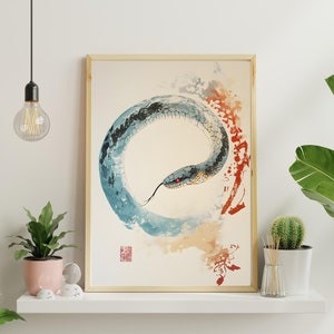 May include: A watercolour painting of a blue snake curled in a circle, with a red eye, on a white background with splashes of orange and blue paint.