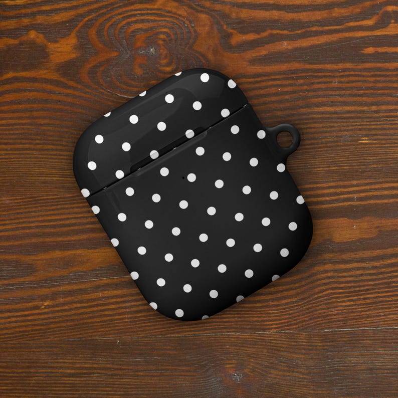 May include: Black and white polka dot silicone case for AirPods.