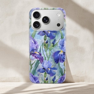 Peut inclure: Coque de téléphone transparente avec un motif floral aquarelle d'iris violets et bleus et de feuilles vertes. La coque a une bordure transparente et recouvre l'arrière d'un smartphone, mettant en valeur les objectifs de l'appareil photo.
