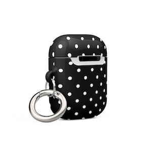 May include: Black and white polka dot silicone case for AirPods with a silver metal carabiner.