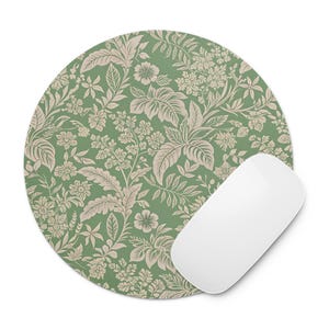May include: Round mousepad with a green floral pattern and a white computer mouse. The mousepad features a repeating design of beige flowers and leaves on a green background. The mouse is white and has a smooth, curved shape.