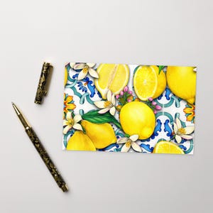 May include: A colorful illustration of lemons and lemon blossoms on a white background with blue and green tile patterns. The lemons are yellow and the blossoms are white with pink centers.