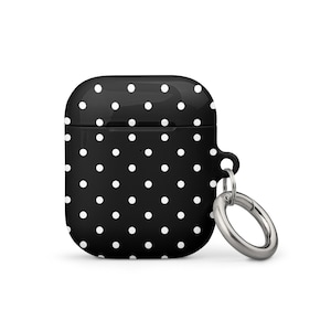 May include: Black and white polka dot Airpod case with a silver carabiner clip.