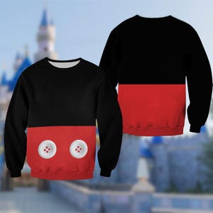 A black and red sweater with a Mickey Mouse design on the front, featuring two white buttons.