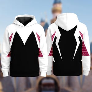 Puede incluir: Sudadera con capucha blanca con un panel frontal negro y detalles blancos. El dise&ntilde;o incluye patrones rojos en forma de telara&ntilde;a en los laterales. La parte trasera de la sudadera tiene un dise&ntilde;o similar. La sudadera tiene capucha y mangas largas.