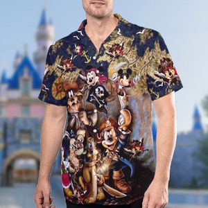 May include: Navy blue short-sleeve button-down shirt featuring a pirate-themed design with Mickey Mouse and friends. The shirt has a map-like background with pirate ship illustrations and nautical elements. The characters are dressed as pirates.