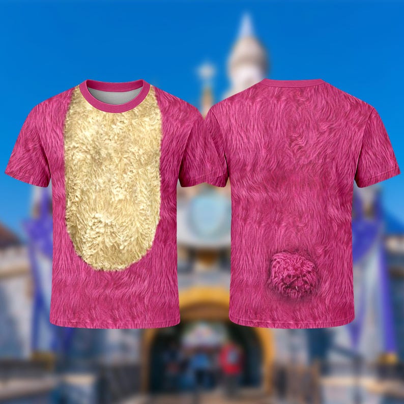 A pink t-shirt with a fuzzy texture and a gold-colored patch on the front, set against a blurred background of a castle or palace.