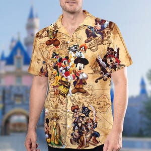 May include: A brown and tan short-sleeved button-up shirt with a vintage-style map print featuring Mickey Mouse and other Disney characters. The map shows various locations like "Parrot's Bay" and "Ghost Hull's Hill".