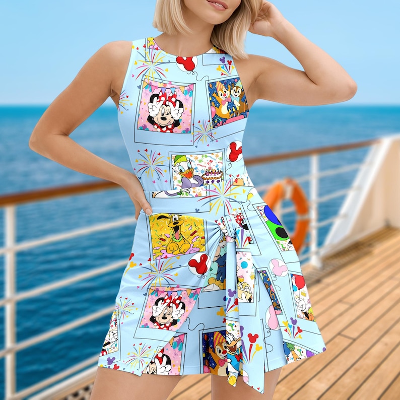 K&ouml;nnte beinhalten: Hellblaues &auml;rmelloses Kleid mit einer Collage von Disney-Charakteren in gerahmten Bildern. Minnie Mouse, Donald Duck, Chip und Chap und Pluto geh&ouml;ren zu den Charakteren. Das Kleid hat einen plissierten Rock und ist mit Feuerwerk und Luftballons verziert.